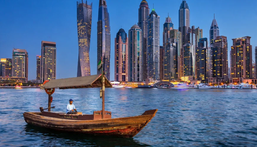 Dubai Marina skyline at blue hour with abra boat — Dubai trip cost guide 2026