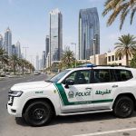 Dubai Police patrol car parked on a city street with high-rise buildings behind