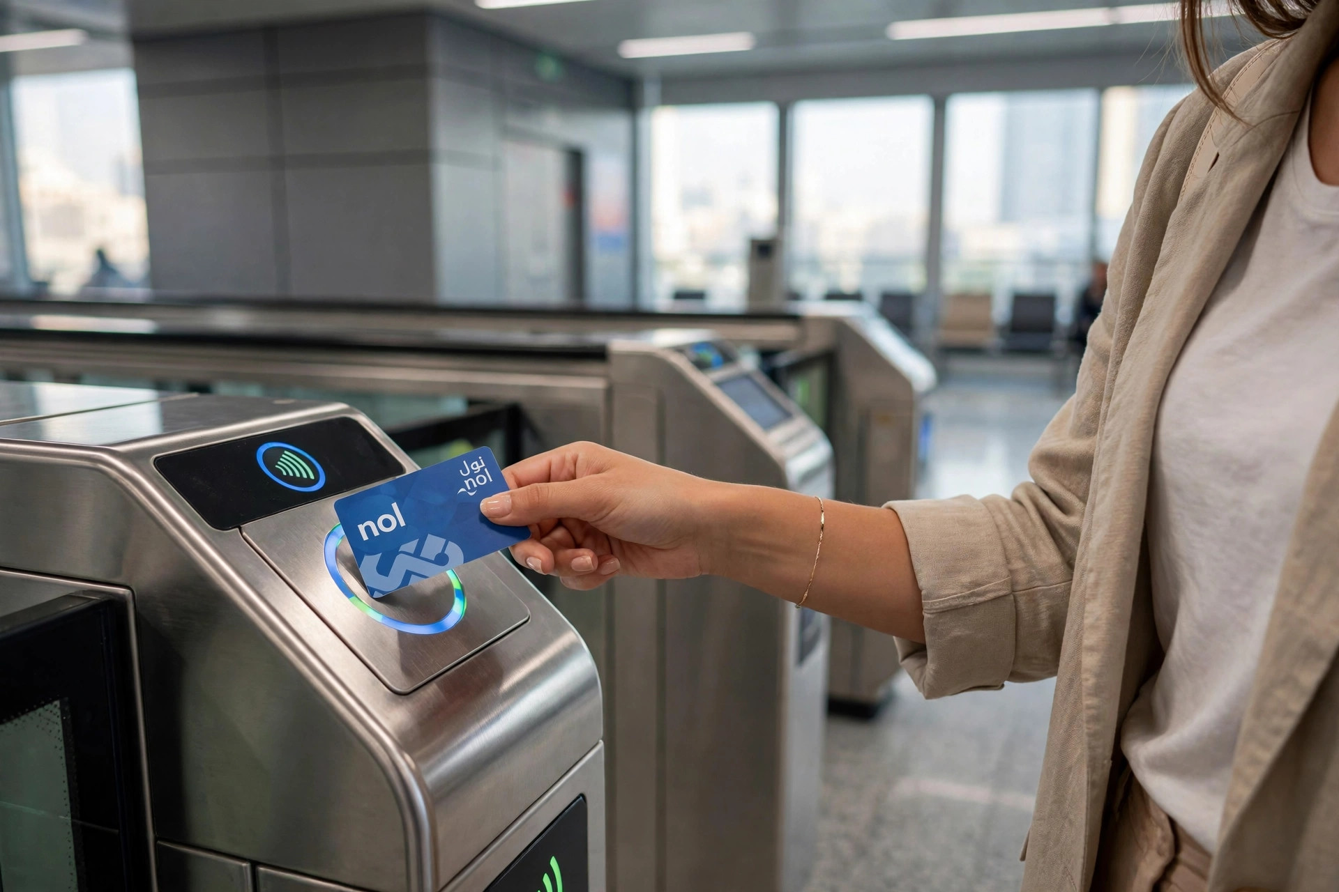 Commuter tapping a nol card on a reader at a Dubai Metro station gate