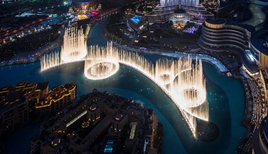 Dubai Fountain show at night with Burj Khalifa rising behind the lake