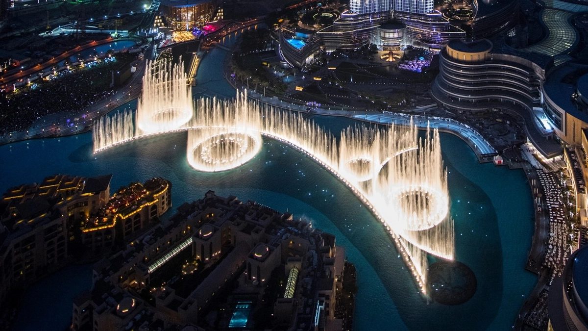 Dubai Fountain show at night with Burj Khalifa rising behind the lake
