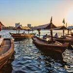 Traditional abra boats crossing Dubai Creek at sunset