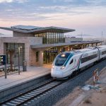 Etihad Rail passenger train approaching Al Yalayis station in Dubai at dawn
