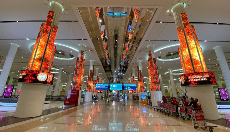 Dubai International Airport at night, with hotels nearby for layovers and early flights
