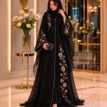 Elegant black abaya with gold floral embroidery in a luxury interior