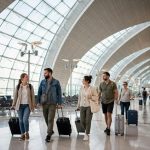 Tourists with luggage walking through Dubai International Airport terminal