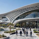 Modern Dubai Exhibition Centre with futuristic glass architecture and visitors at the entrance