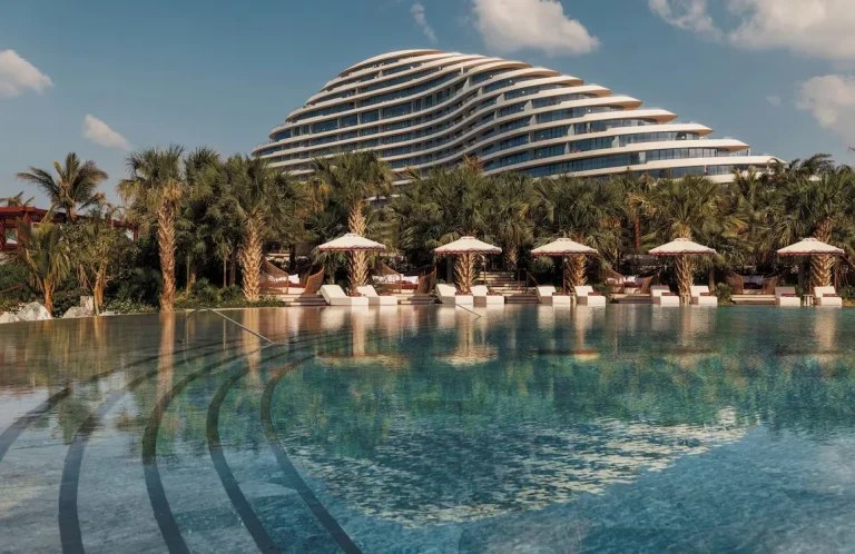 Curved superyacht-inspired facade of Jumeirah Marsa Al Arab resort beside the beach
