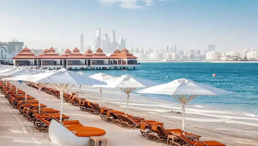 Over-water villas and beach loungers at a luxury Palm Jumeirah beachfront hotel
