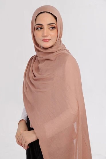 A woman wearing a lightweight nude-toned modal hijab in soft daylight