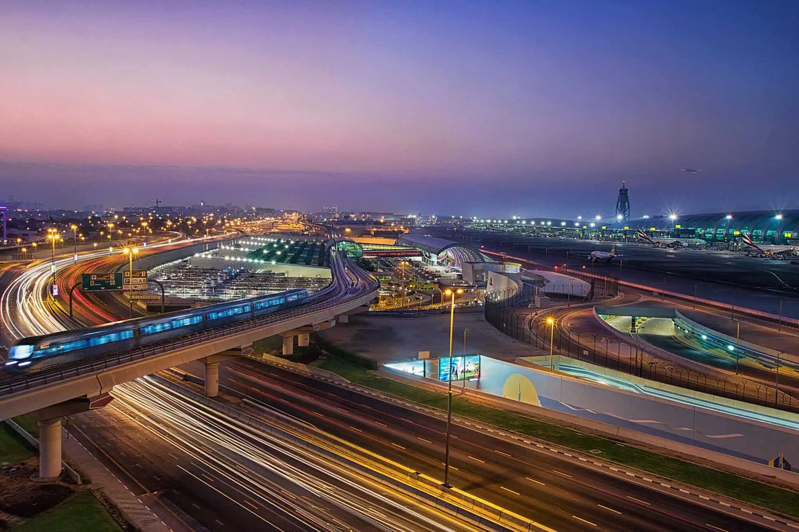 Dubai International Airport and the Dubai Metro glowing at night