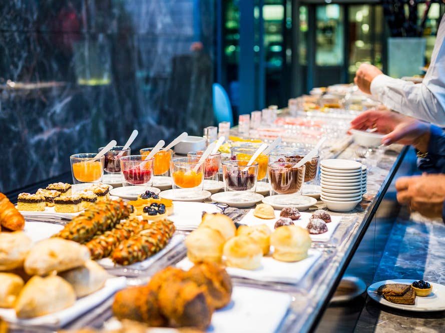 Hotel breakfast buffet with pastries, fruits and hot dishes