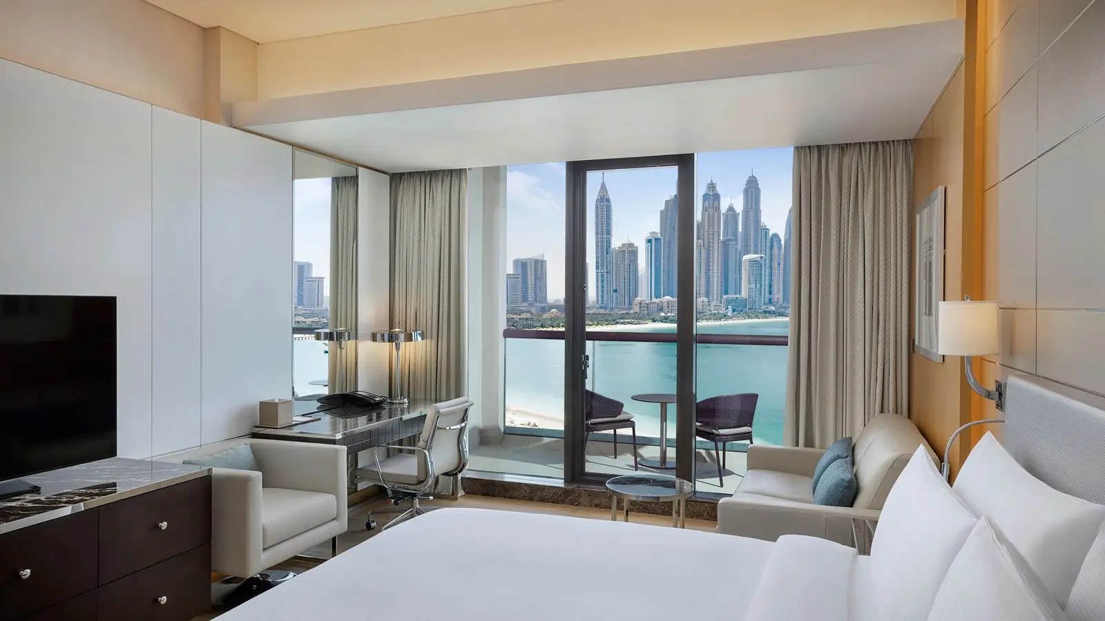 Elegant luxury hotel suite in Dubai with plush bedding and warm evening lighting