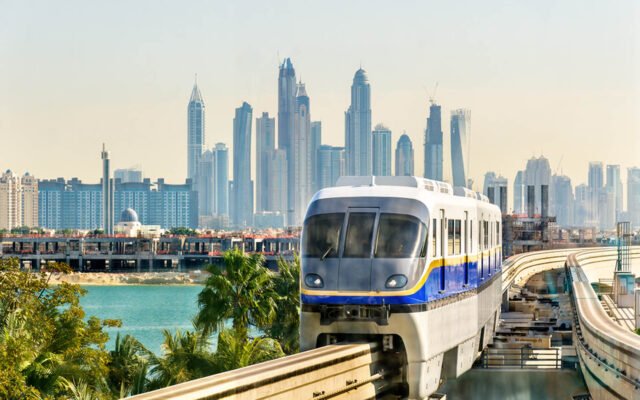 The Palm Jumeirah monorail train crossing the island with the Dubai skyline behind
