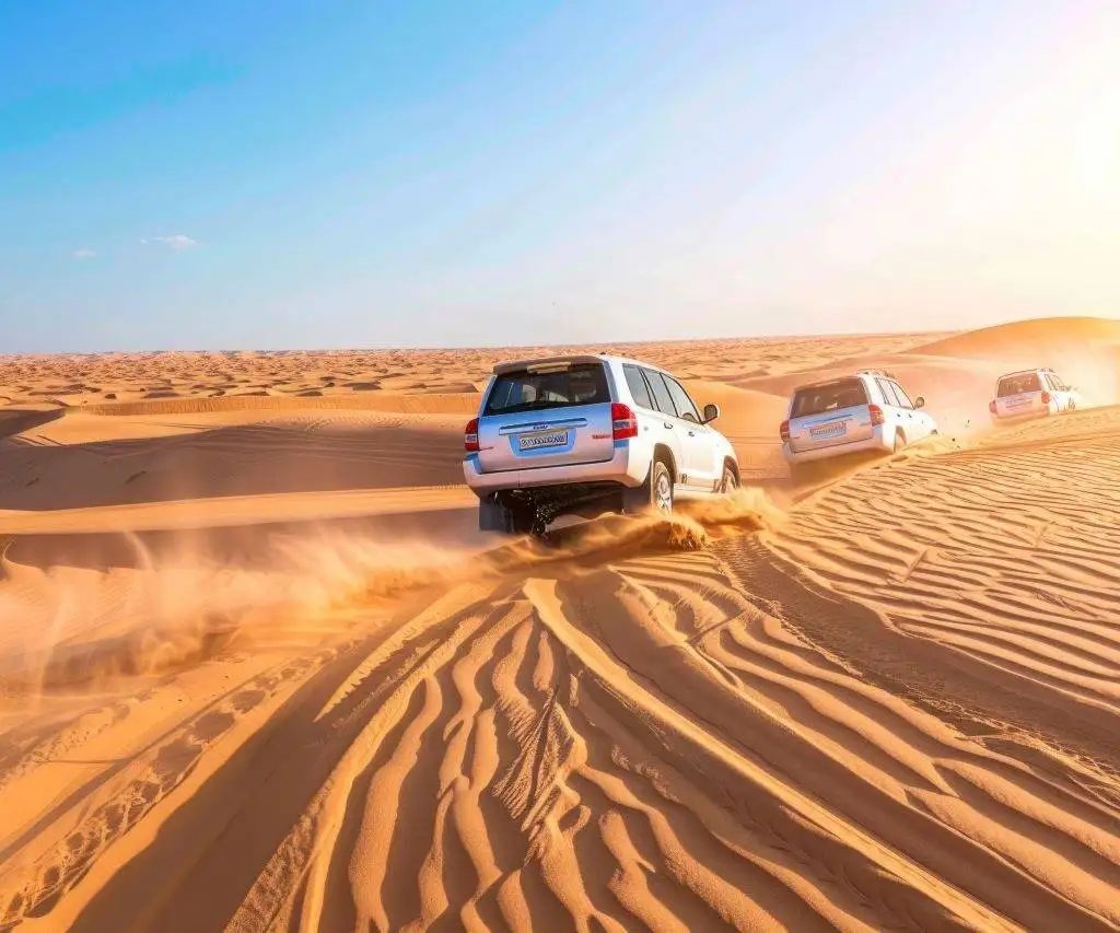 4x4 vehicles on a desert safari crossing golden sand dunes near Dubai