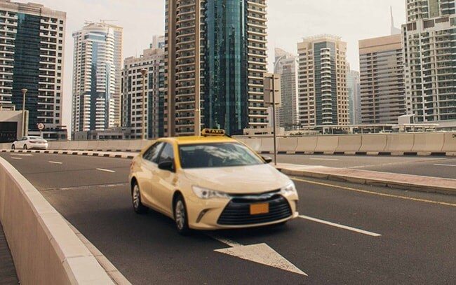 A Dubai taxi driving on the road near the city
