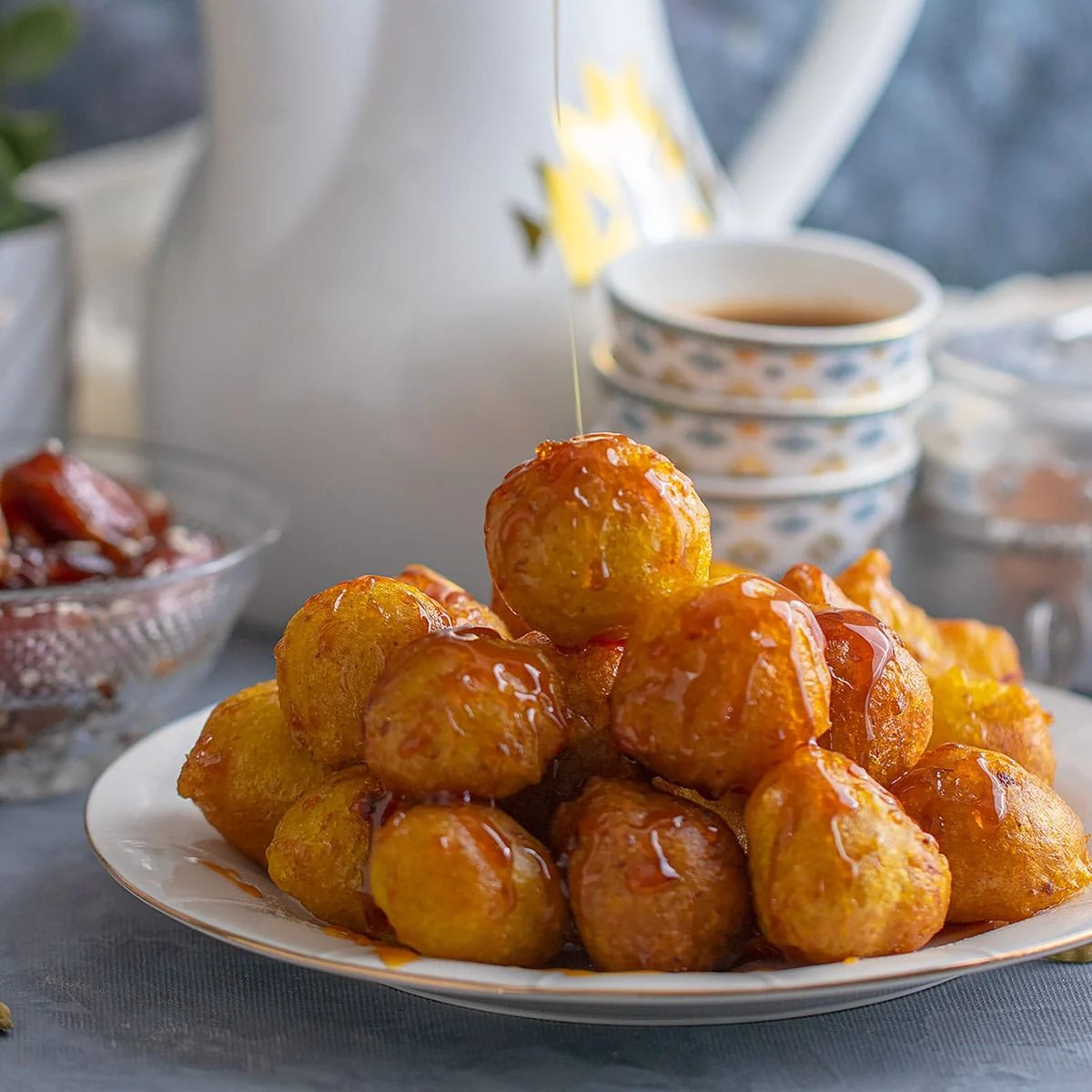 Golden luqaimat dumplings drizzled with date syrup