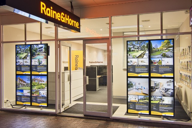 Investors reviewing property listings on screens in an office