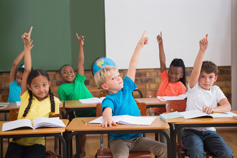 School students raising hands during a lesson