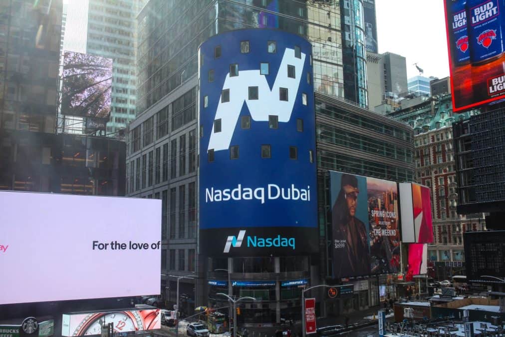 Investor checking a stock market app on a phone in Dubai