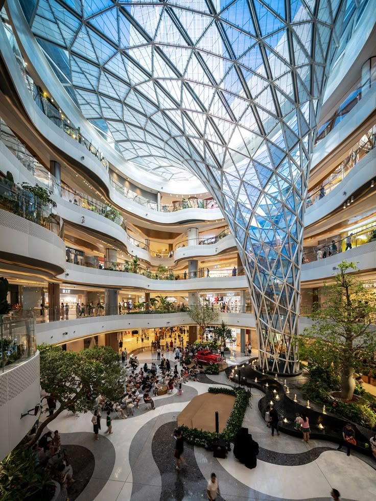Shoppers walking through a large contemporary mall atrium