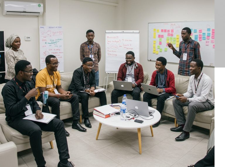 Young tech founders working on laptops at a workshop