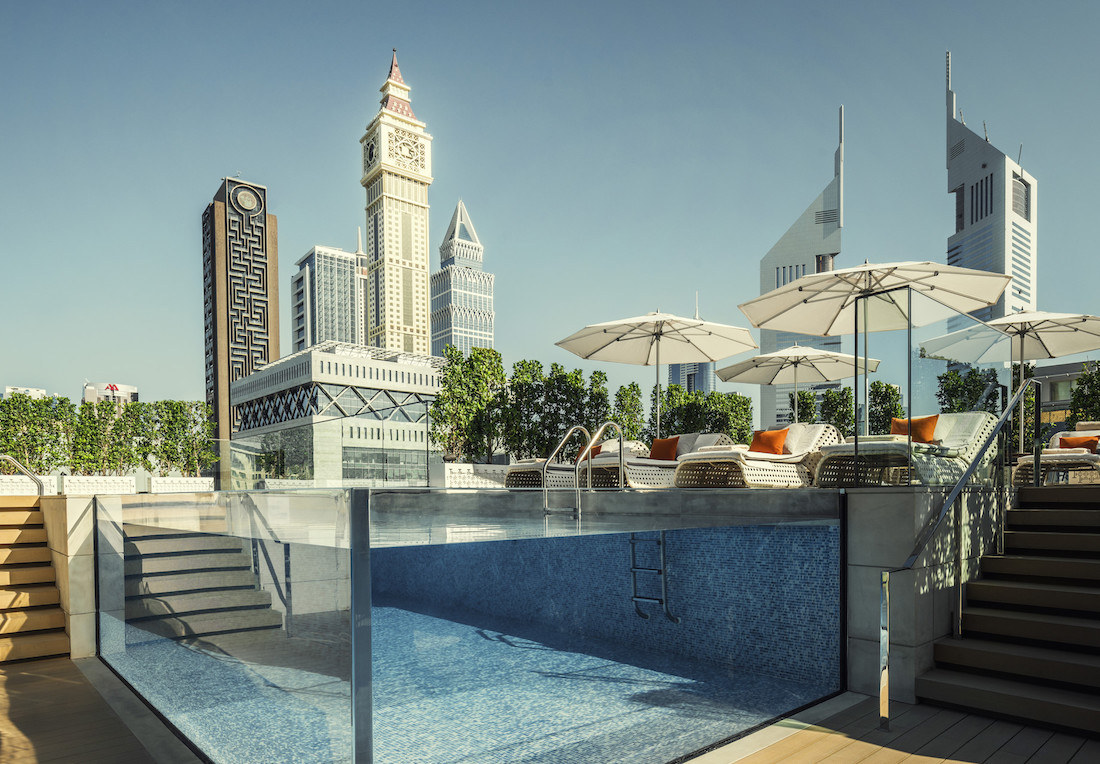 Rooftop pool at a DIFC hotel with the Dubai skyline behind it