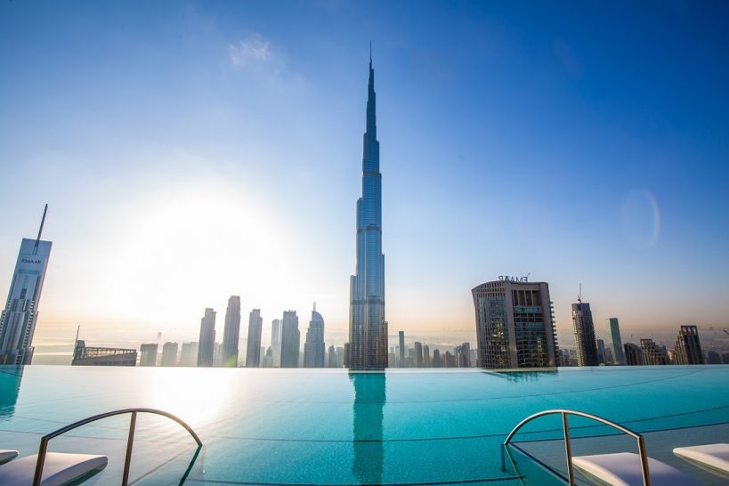 Infinity pool high above Downtown Dubai with Burj Khalifa in front of swimmers