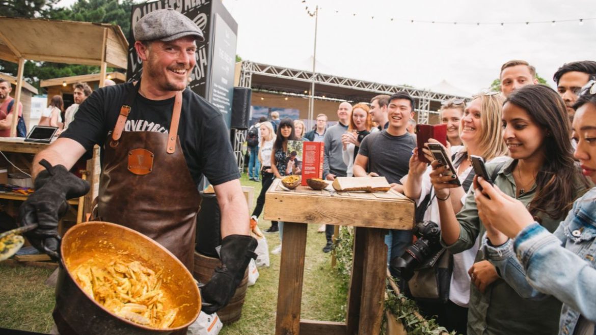 Visitors tasting and buying produce at a farmers market stall