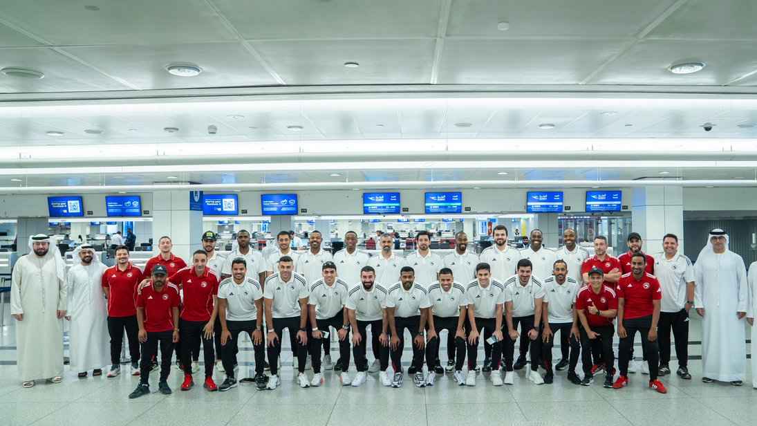 Supporters in UAE colours boarding a flight at an airport departure hall