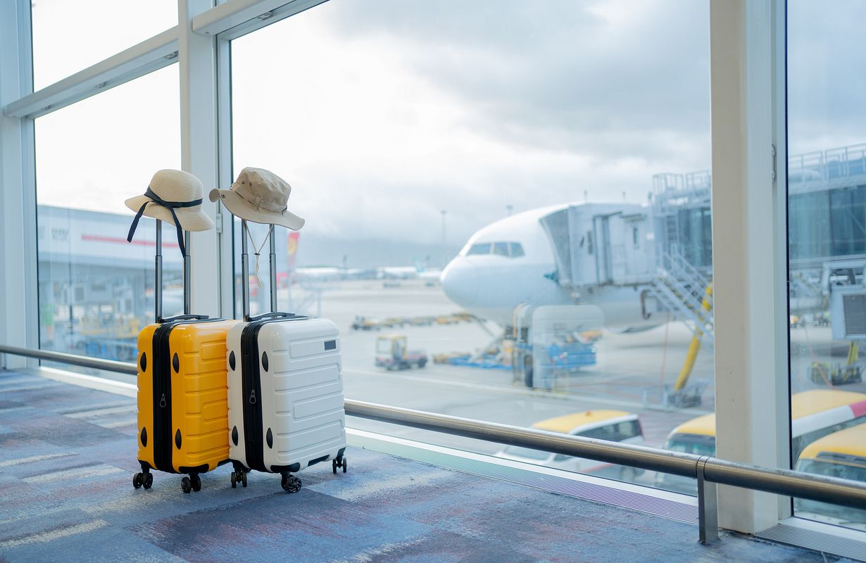 Travellers with luggage walking through an airport departure hall