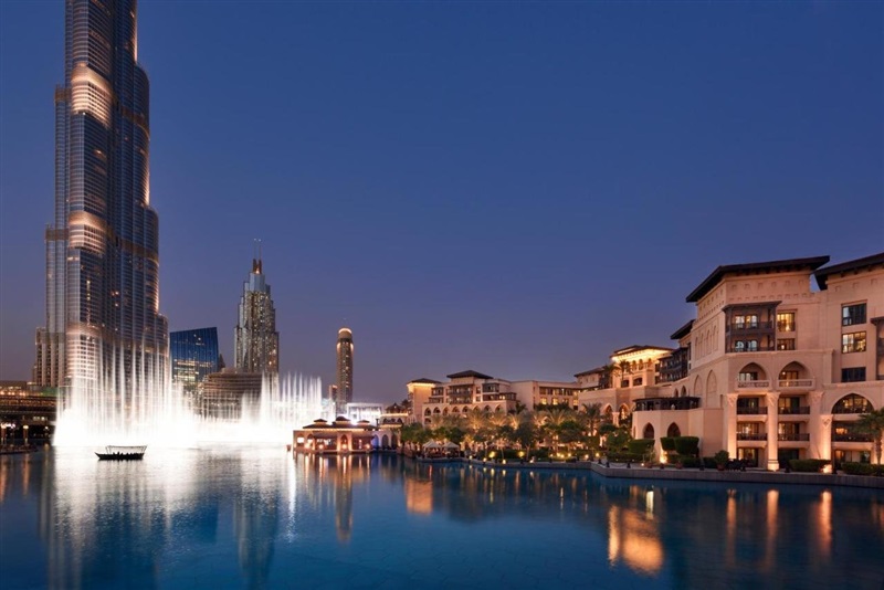 Palatial hotel reflected in Burj Lake with Burj Khalifa rising behind it