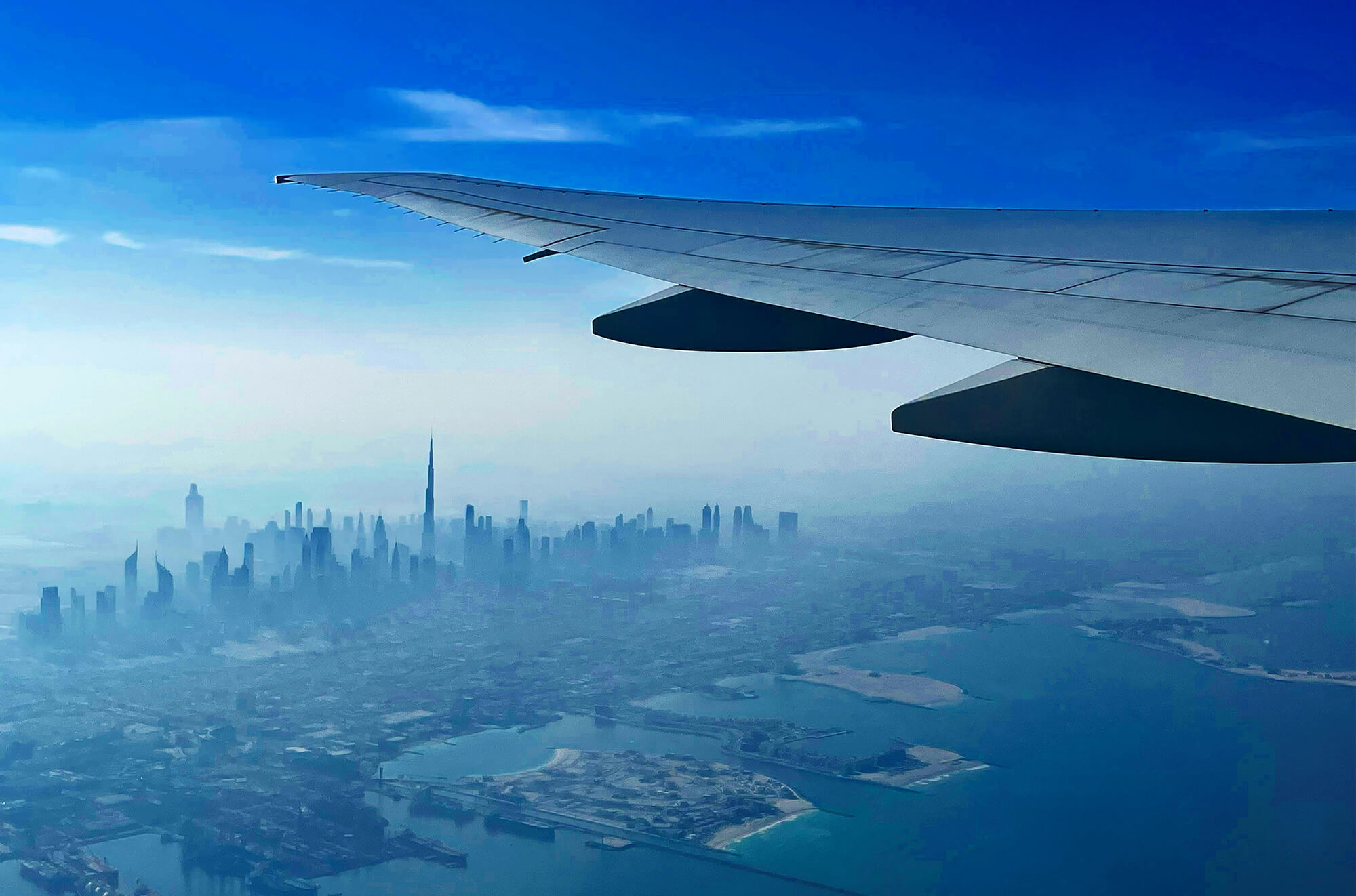 Airplane wing over Dubai skyline during approach