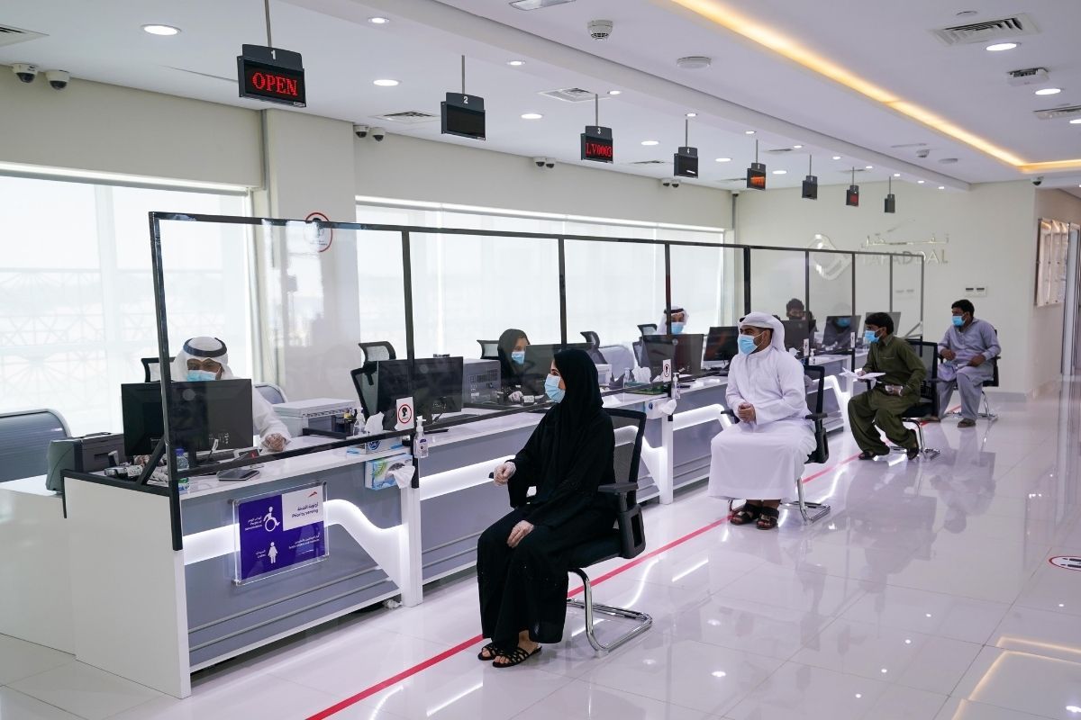 Dubai Land Department style service centre with customers at counters