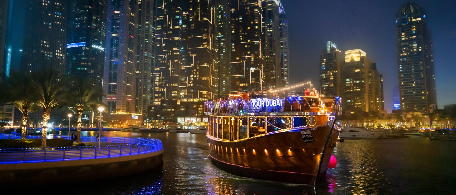 Traditional dhow cruise boat sailing through Dubai Marina at night