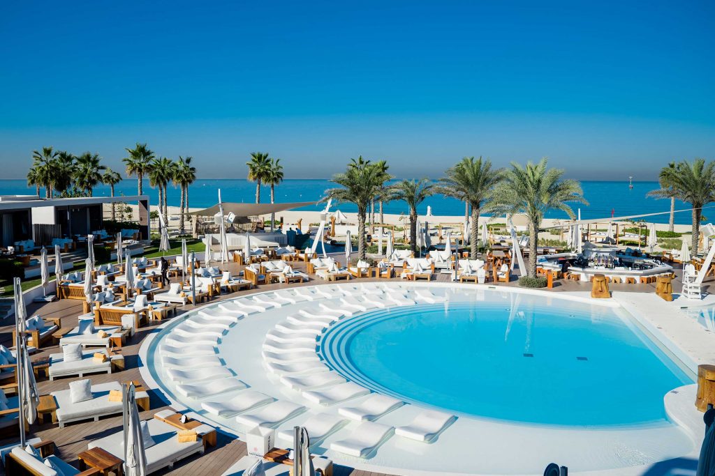White contemporary resort buildings around a bright pool near the beach at Pearl Jumeira