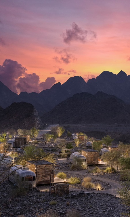 Hatta Caravan Park bespoke caravans with mountain backdrop at dusk