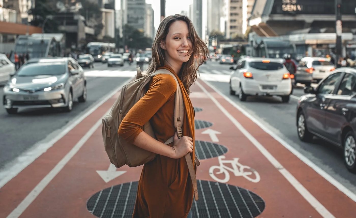 A solo traveller with a backpack walking through a modern Dubai street