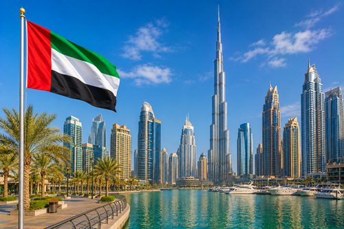 The UAE flag flying in front of modern buildings in Dubai