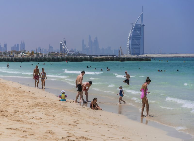 Visitors swimming and relaxing at a Dubai public beach in winter