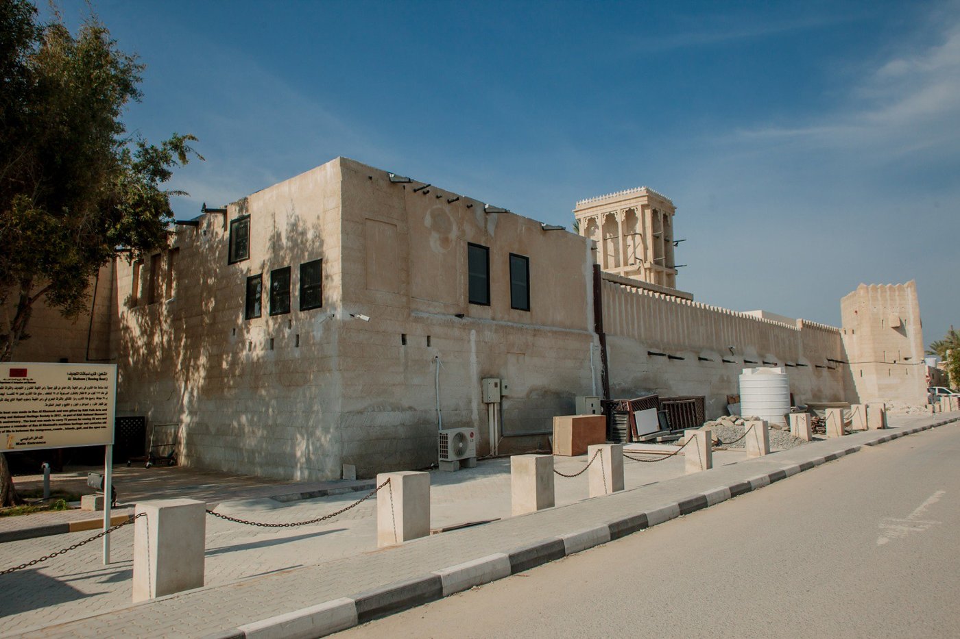Coral-stone houses along a sandy lane in Al Jazirah Al Hamra heritage village