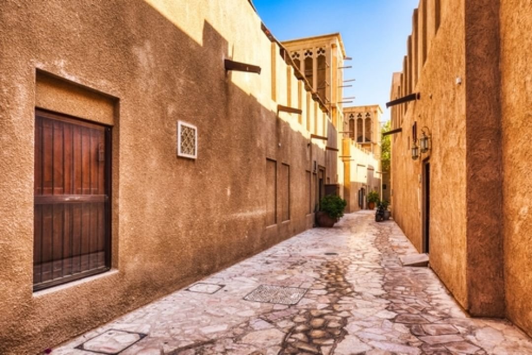 Narrow lane between sand coloured heritage houses in Al Fahidi Dubai