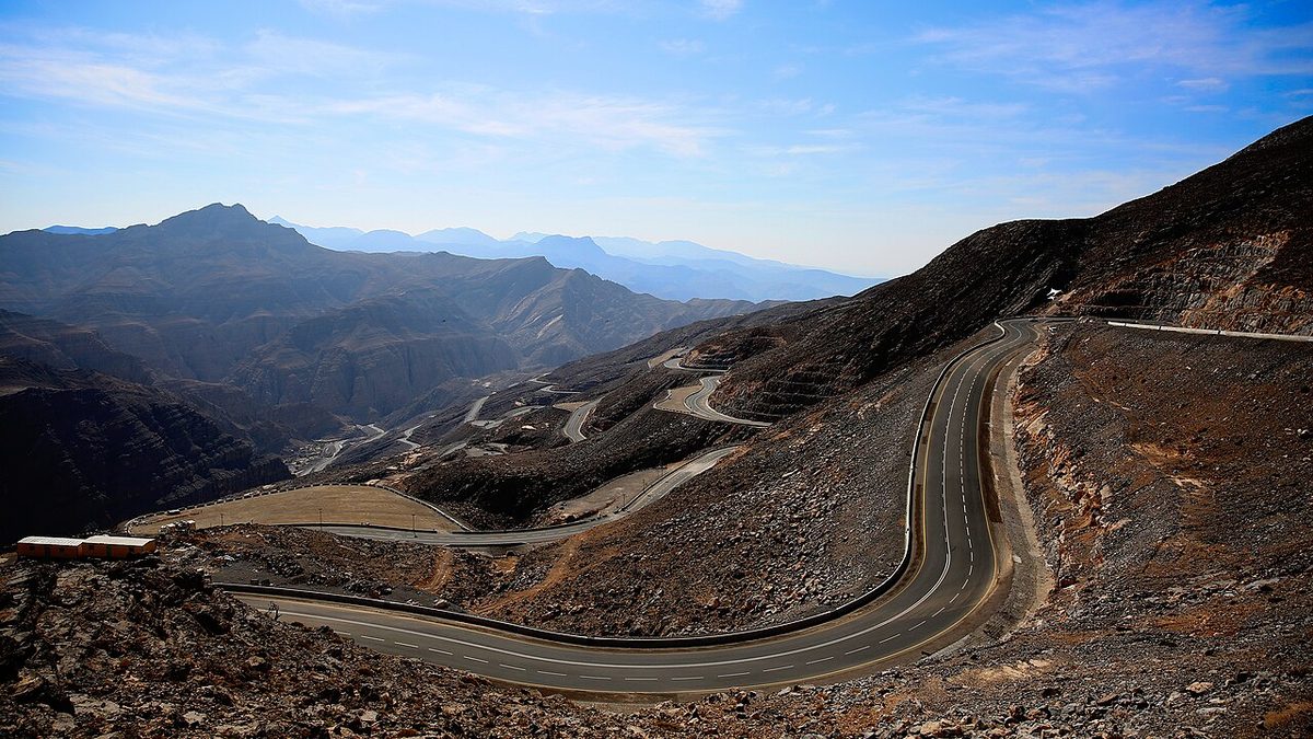 Winding mountain road climbing through the Hajar mountains toward the Jebel Jais summit