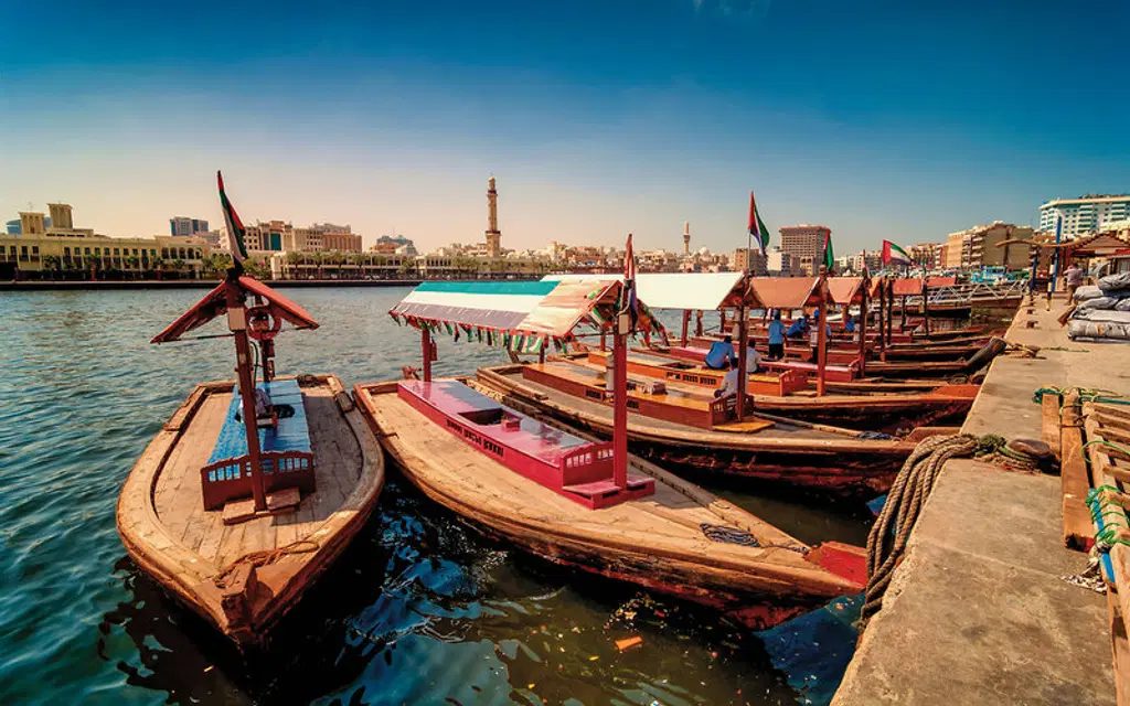 A wooden abra boat carrying passengers across Dubai Creek in Deira