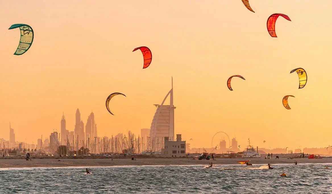 Kitesurfers riding off Kite Beach in Dubai with the city behind