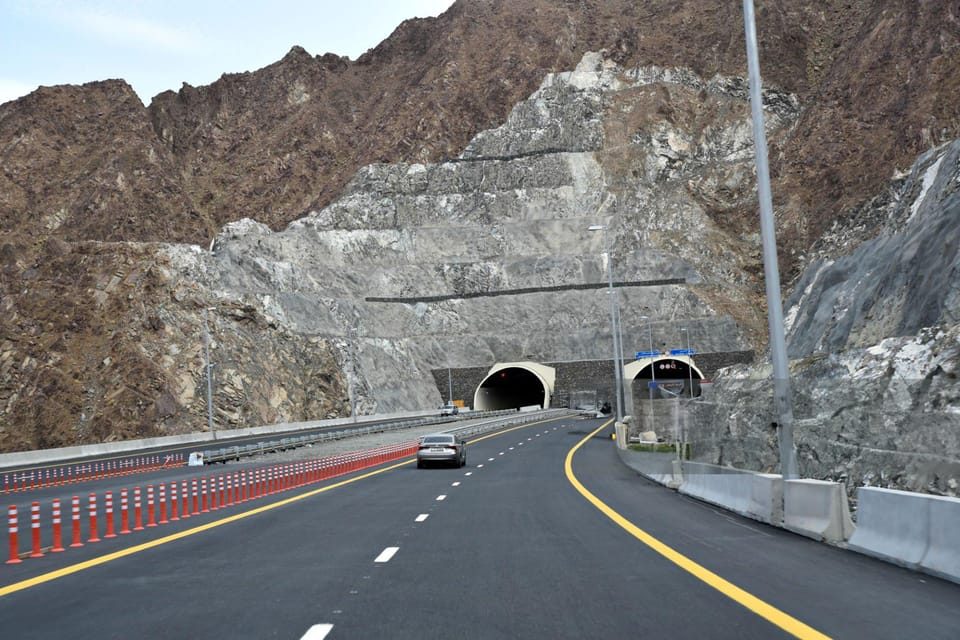 A highway cutting through the Hajar Mountains toward the east coast