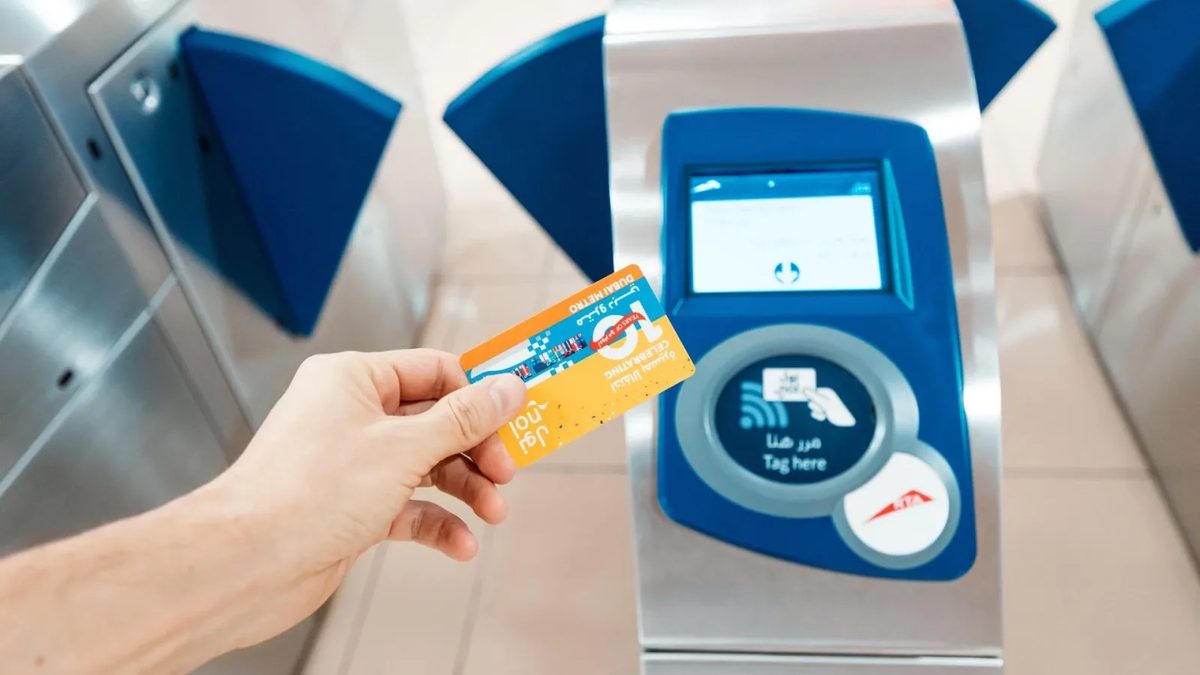A traveller tapping a Nol card at a Dubai Metro gate