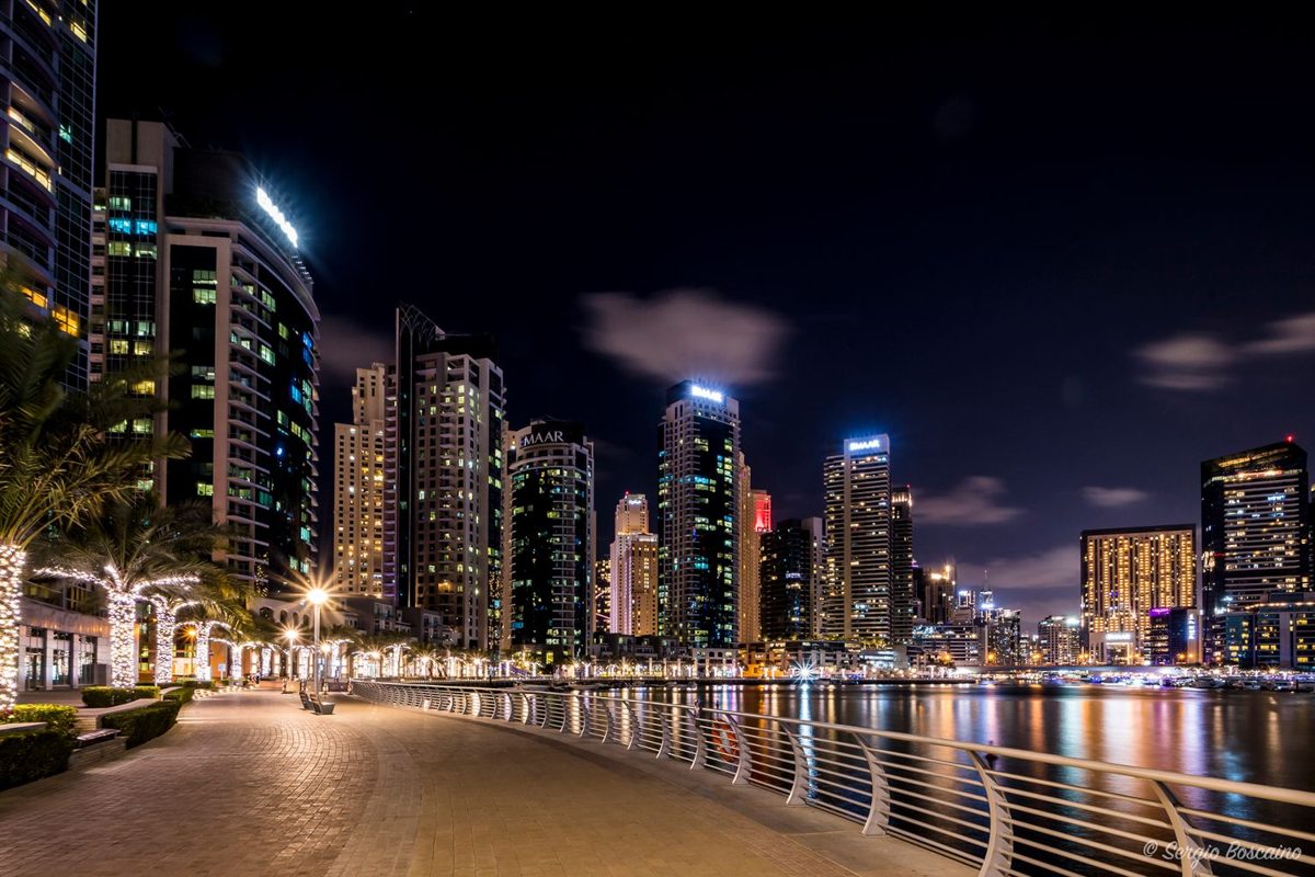 People walking the Dubai Marina promenade at night