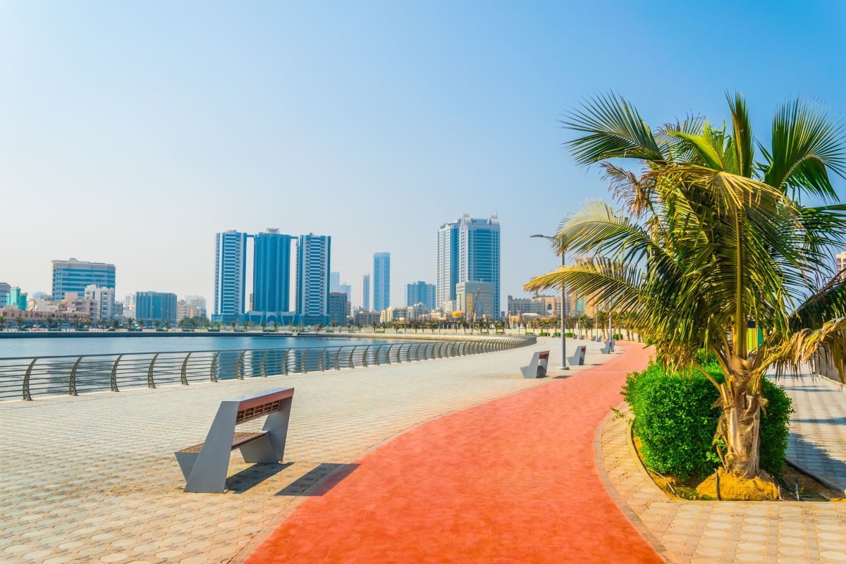 People enjoying the wide sandy beach along Ajman Corniche