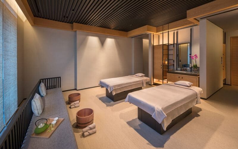 A calm couples' spa treatment room with two massage beds in a Dubai hotel